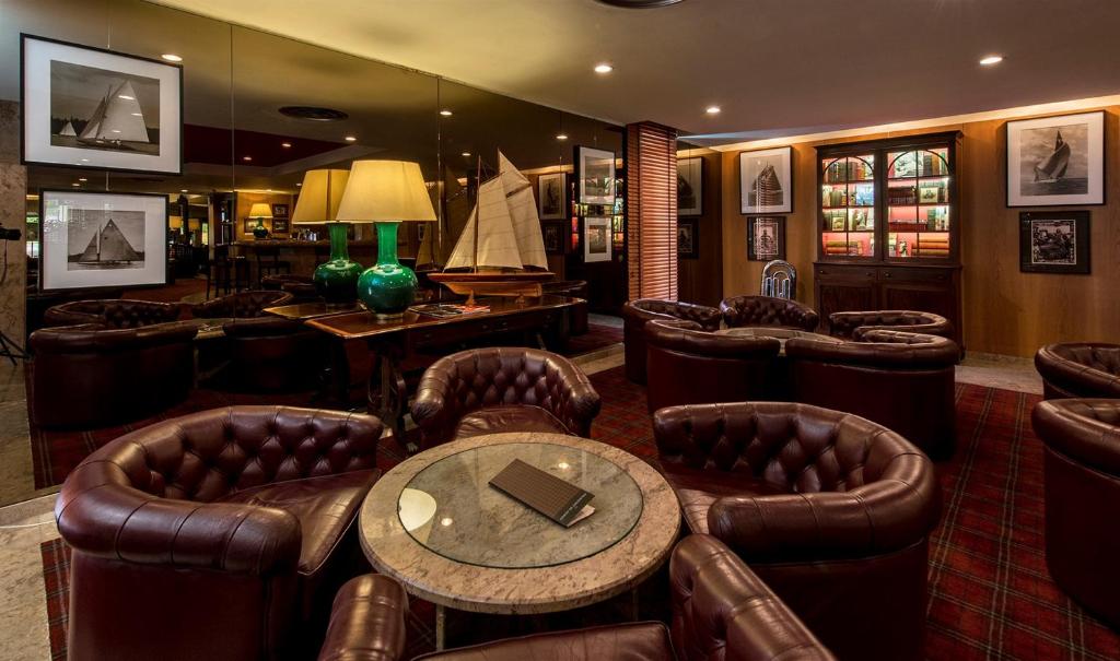 a bar with leather chairs and a table with a laptop on it at Hotel Solverde Spa and Wellness Center in Vila Nova de Gaia