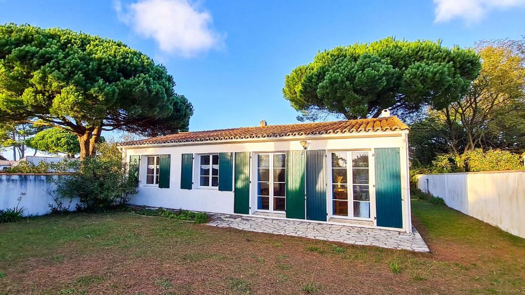 a small house in a yard with trees at Villa au calme à proximité de la mer in La Couarde-sur-Mer