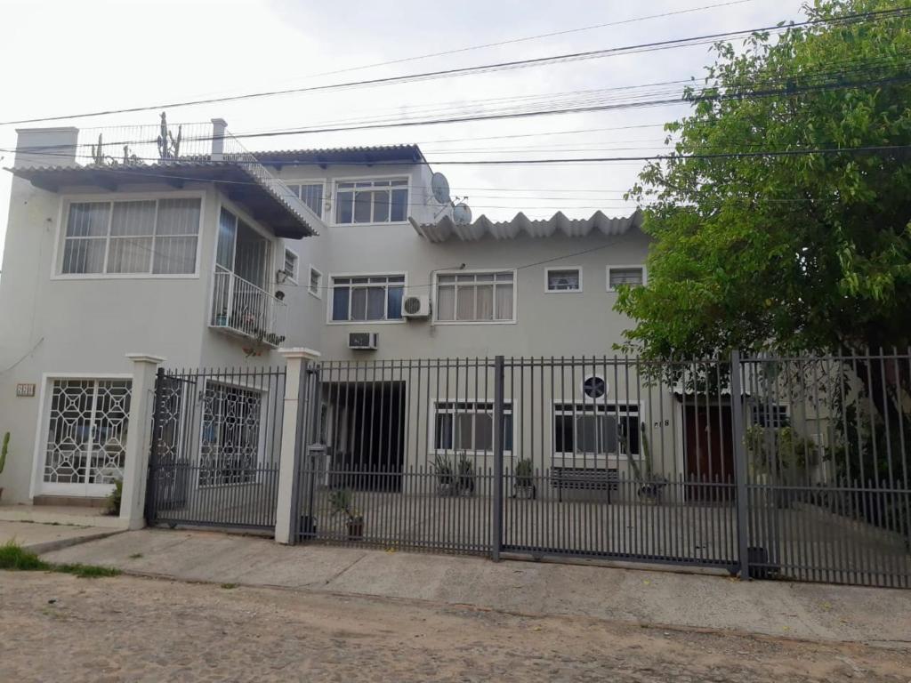 une maison blanche avec une clôture devant elle dans l'établissement Casa e Ateliê de pintura Neiva Mario, à São Gabriel