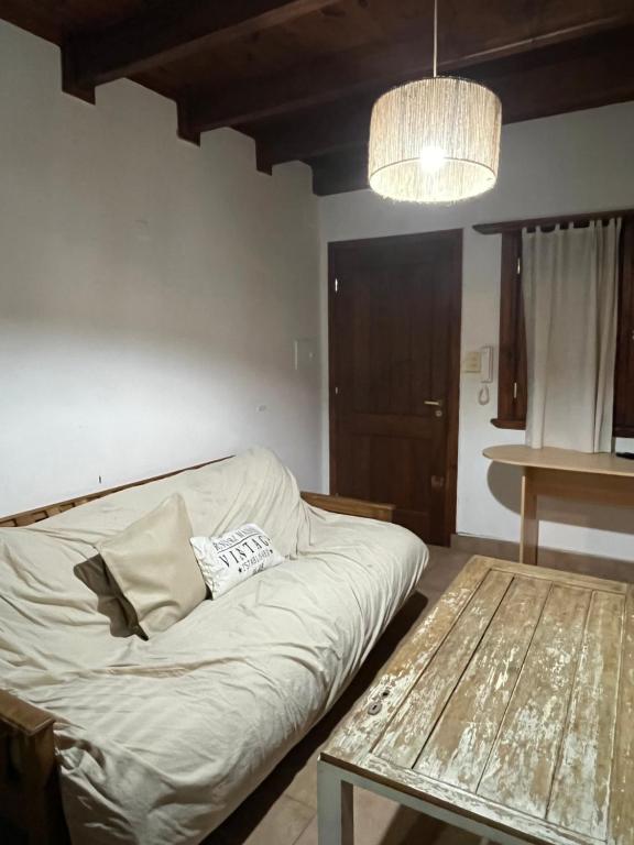 Sala de estar con cama y mesa en Casa en alquiler TANDIL - Lamadrid en Tandil