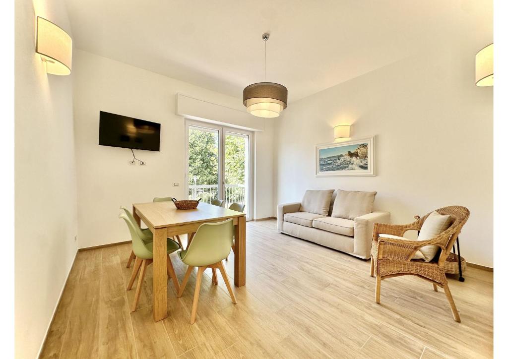 een woonkamer met een tafel en stoelen en een bank bij (3 suites in the sea) luxe apartment in Camaiore