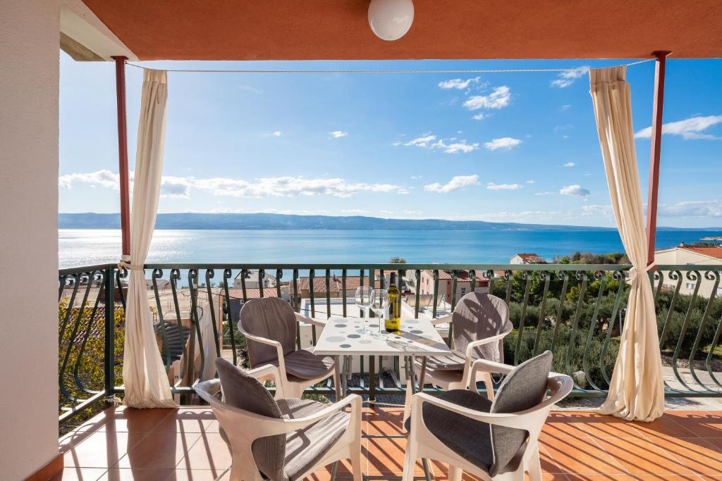 uma varanda com mesa e cadeiras e vista para o oceano em Apartment Sapphire Suite em Duće