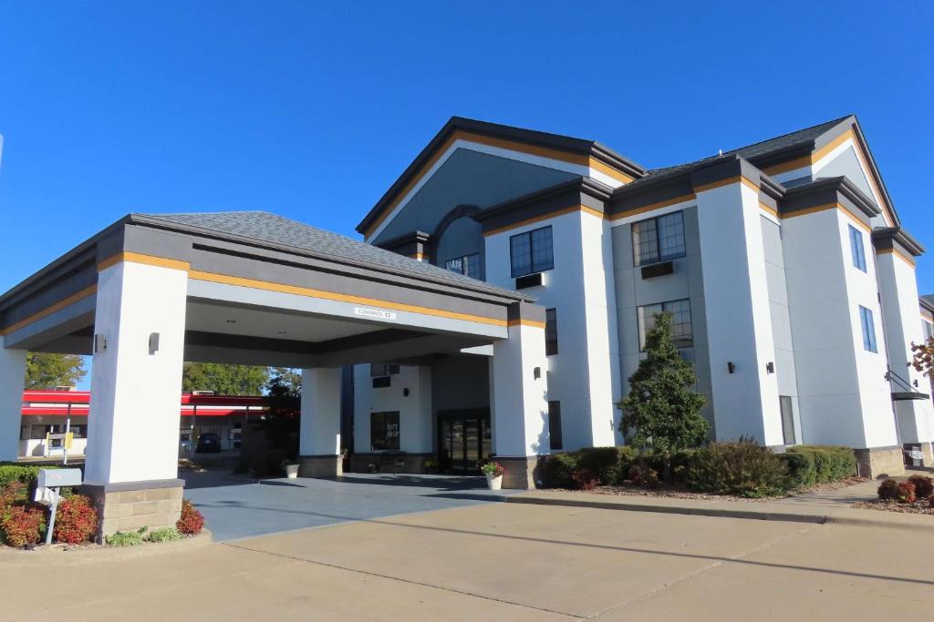 a large white building with a parking garage at Best Western Prime Inn & Suites in Poteau