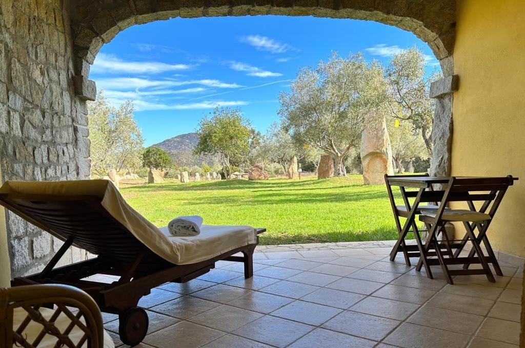 een veranda met een hangmat en uitzicht op een veld bij Hotel I Menhirs in Annunziata