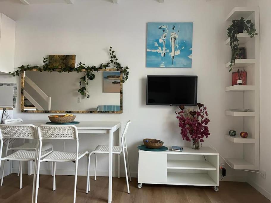 a dining room with a table and chairs and a tv at Casa Cactus Paraiso in Parque Holandes