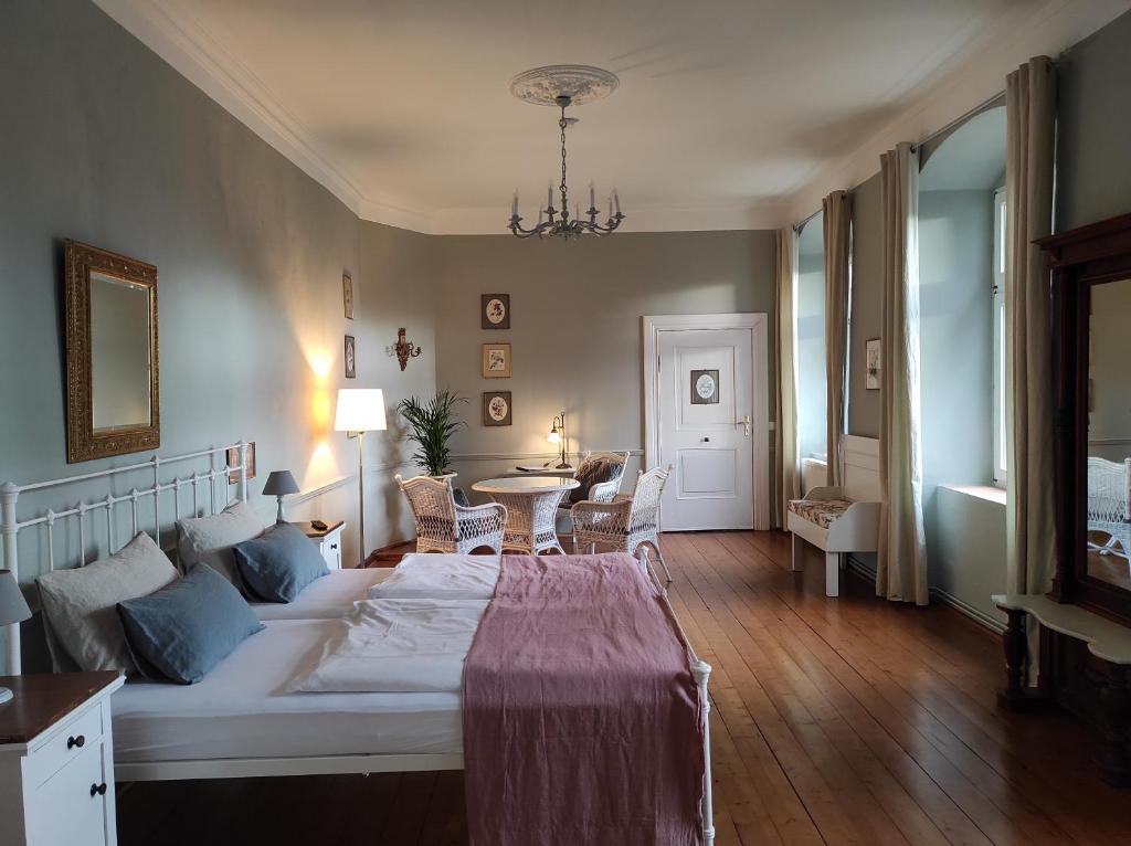 Neuhausen的住宿－Gartenzimmer im Schloss Neuhausen，卧室配有一张床和一张桌子及椅子