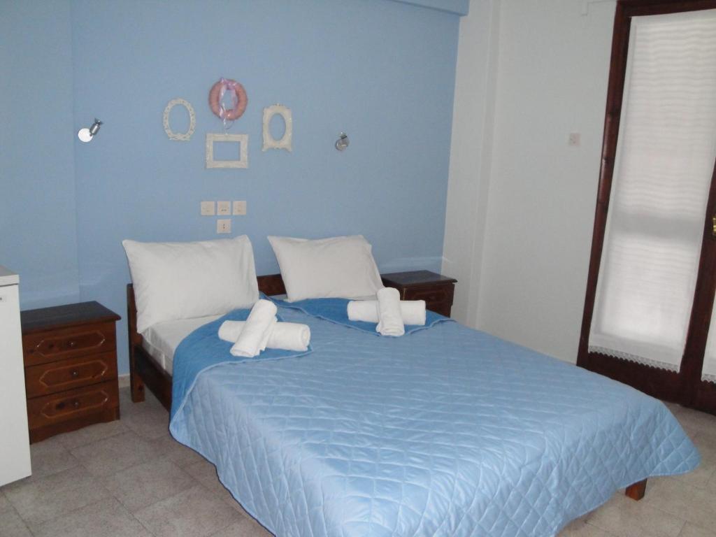 1 dormitorio con cama azul y almohadas blancas en Filia, en Skiathos