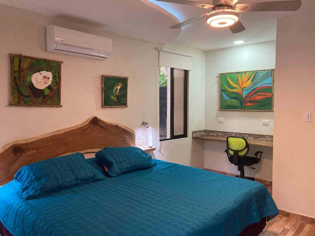 a bedroom with a bed with a blue comforter at Garza Tigre Apartamentos in Cóbano