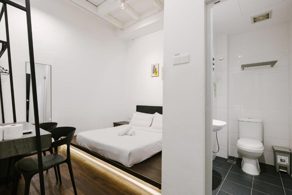 una camera con letto, servizi igienici e lavandino di Kangsar Inn 73 a George Town