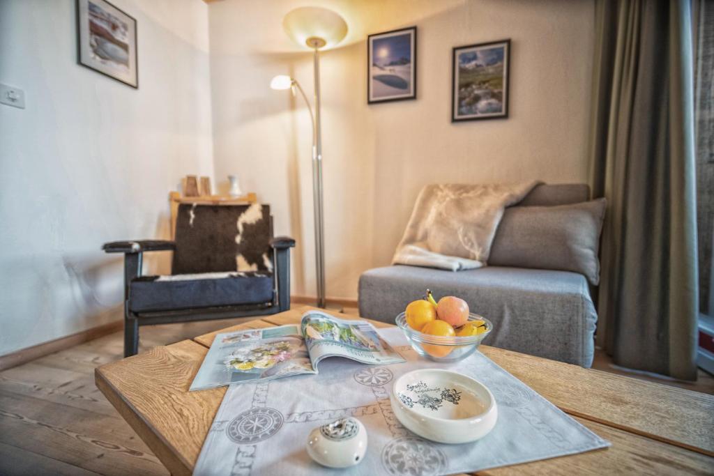 ein Wohnzimmer mit einem Tisch und einer Obstschale darauf in der Unterkunft Chasa Gisep in Scuol