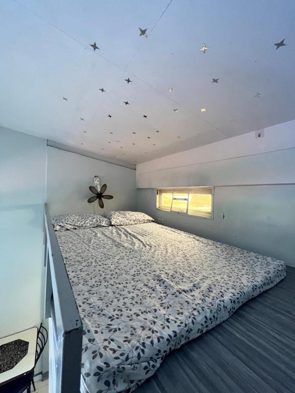 1 dormitorio con 1 cama en una habitación con estrellas en el techo en JC Unit #7, en Urdaneta
