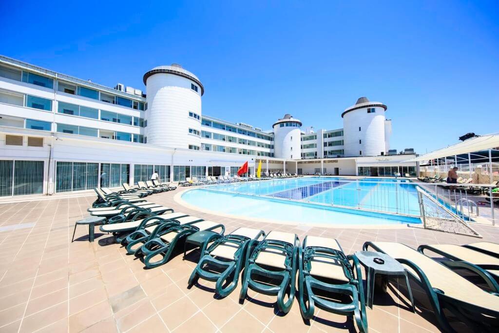 eine Reihe von Liegestühlen neben einem Pool auf einem Kreuzfahrtschiff in der Unterkunft Jura Hotels Kemer Resort in Kemer