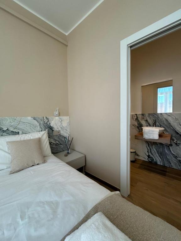 a bedroom with a large white bed and a mirror at Breccia Nel Mare in Carrara