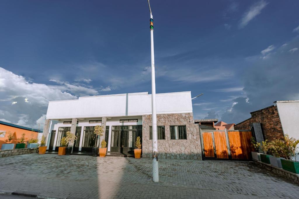 um mastro de bandeira em frente a um edifício branco em Makeri Residence - Musanze , Rwanda em Ruhengeri