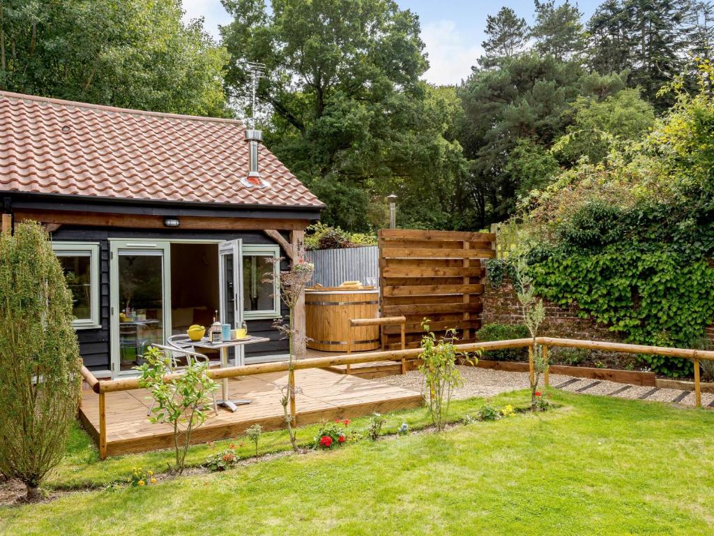 a garden with a wooden deck and a house at 1 Bed in Dereham 78596 in Bawdeswell