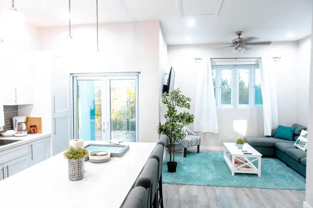a white living room with a couch and a table at EXCLUSIVE Modern Apartment in Nasáu, Bahamas in Nassau