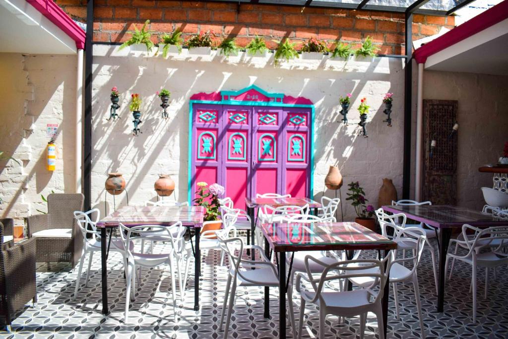 a restaurant with tables and chairs and a pink door at CASA HOTEL LAS HORTENSIAS in Jardin