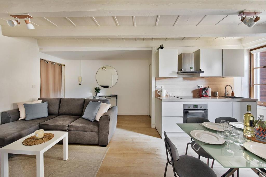 uma sala de estar com um sofá e uma mesa em Appartement Eglise Notre-Dame-des-Calades em Villefranche-sur-Saône