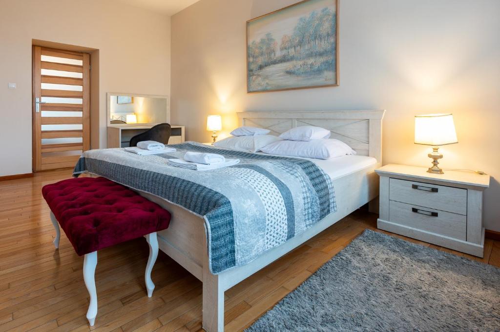 sypialnia z dużym łóżkiem i czerwonym krzesłem w obiekcie Apartamenty Galicja w mieście Przemyśl