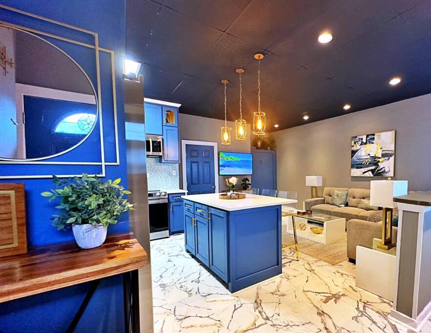 a kitchen with blue cabinets and a living room at The Q Loft Galveston in Galveston