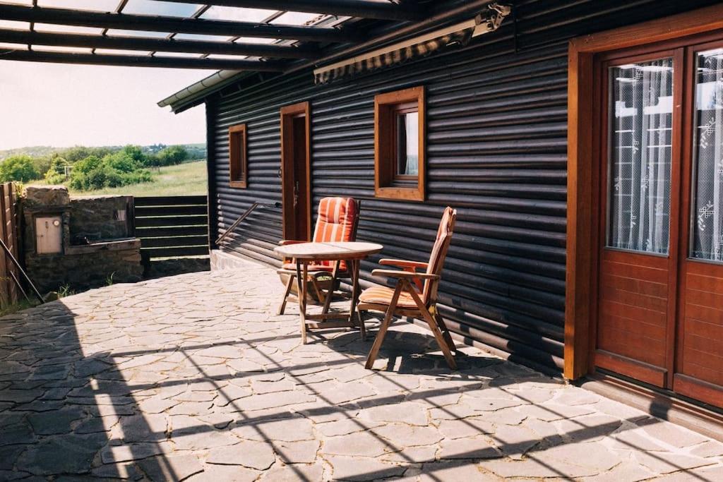 un patio con 2 sillas y una mesa en una casa en Krásný srub na jihu Brna, en Želešice