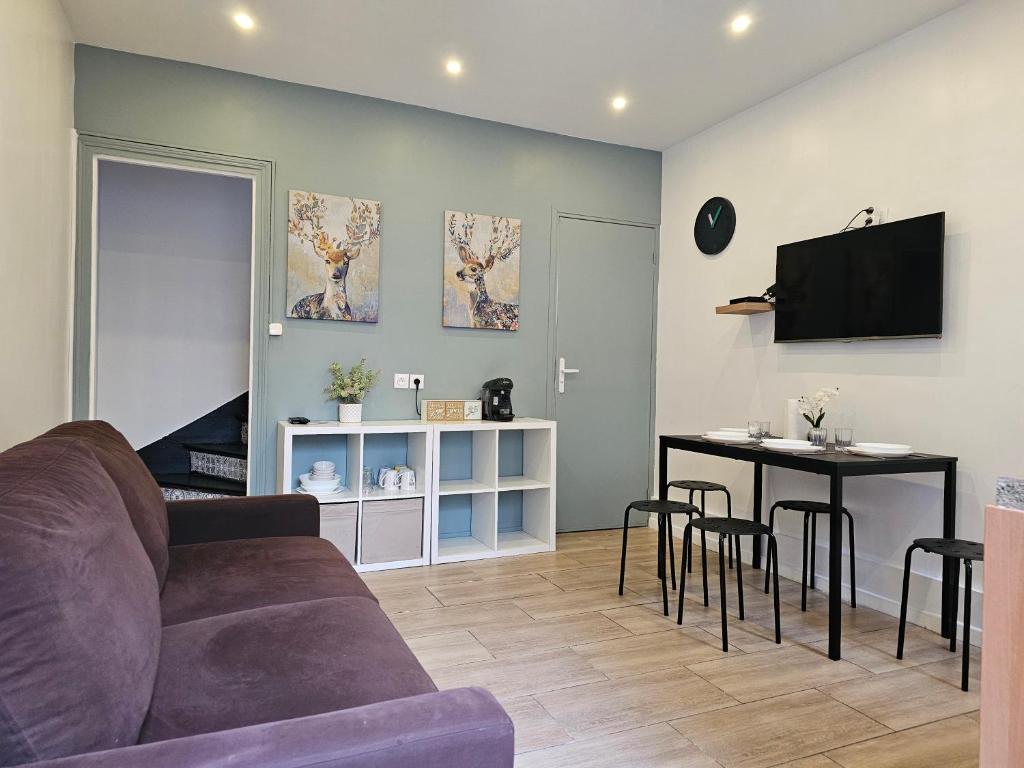 een woonkamer met een bank en een tafel bij Maison rénovée proximité de paris 20eme in Bagnolet