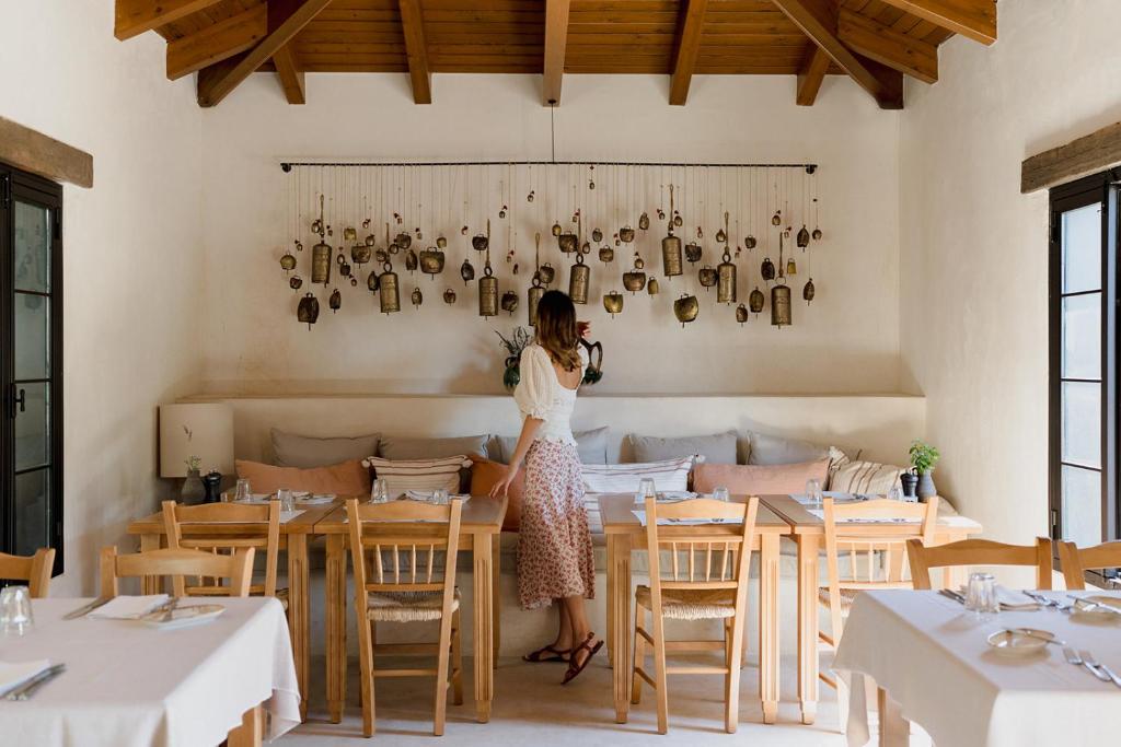 Eine Frau, die an einem Tisch in einem Restaurant steht. in der Unterkunft Village Heights Resort in Hersonissos