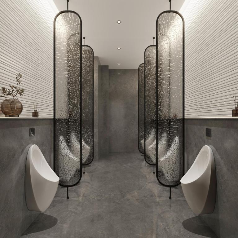 a bathroom with three urinals and a row of sinks at Argyle Grand Hotel Nairobi Airport in Nairobi