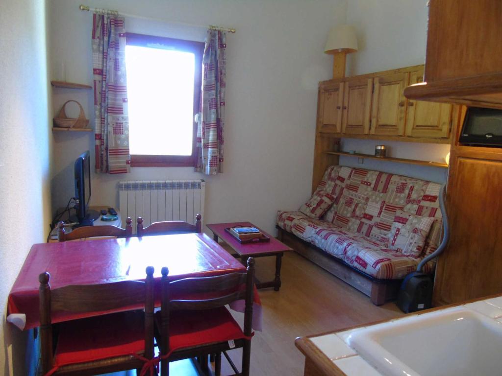 a living room with a table and a bed at Appartement Valfréjus, 2 pièces, 4 personnes - FR-1-561-50 in Valfréjus