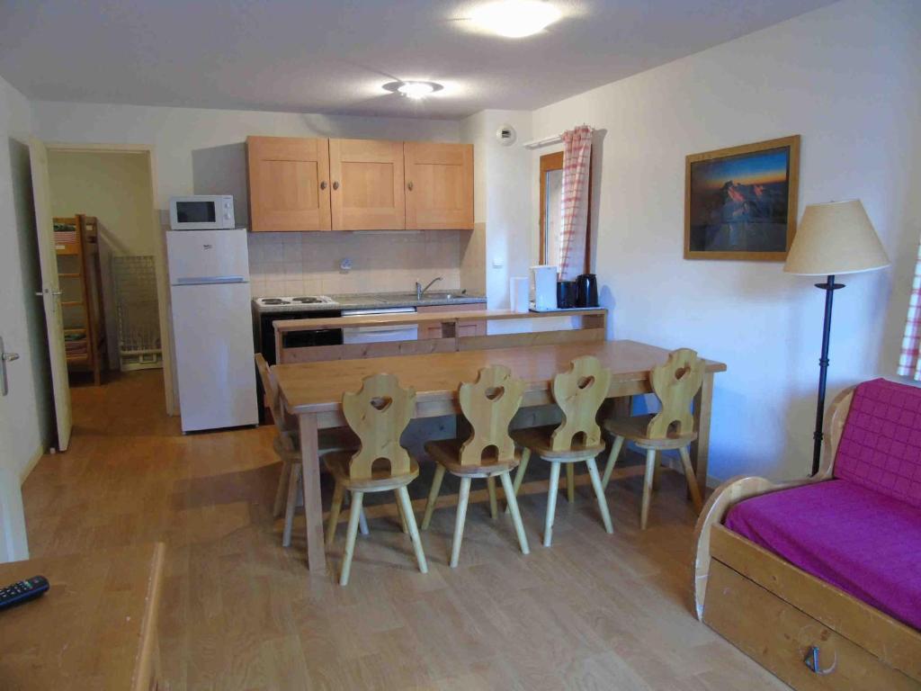 eine Küche und ein Esszimmer mit einem Tisch und Stühlen in der Unterkunft Appartement Valfréjus, 3 pièces, 8 personnes - FR-1-561-55 in Valfréjus