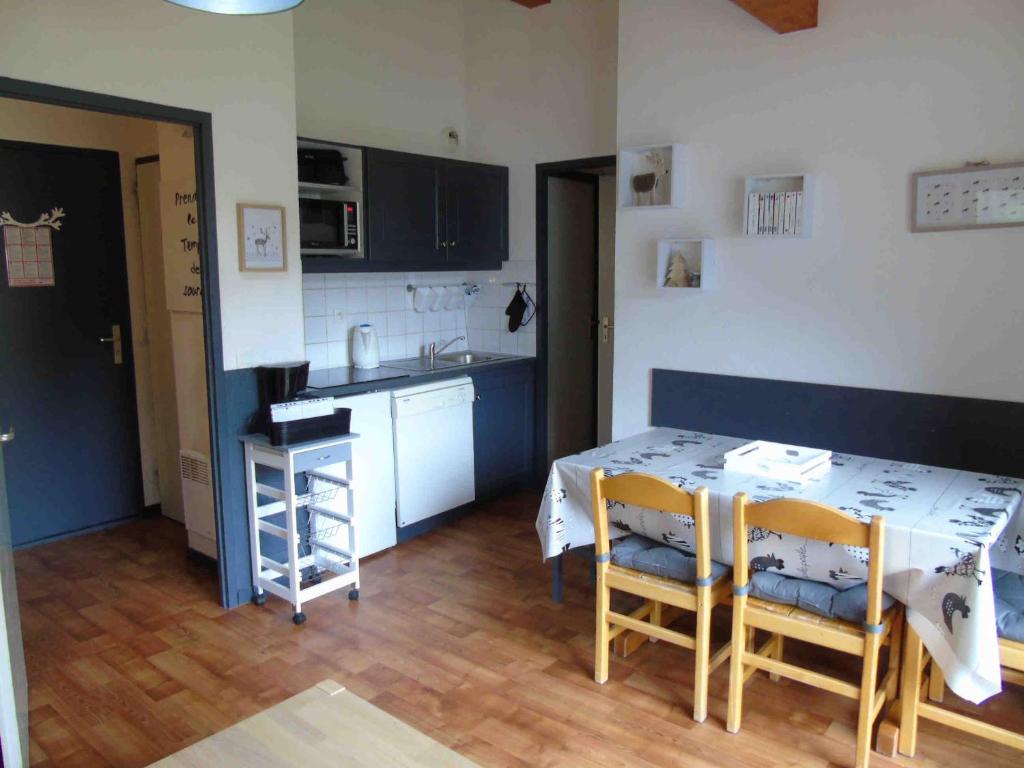 une cuisine avec une table et des chaises dans une pièce dans l'établissement Appartement familial à Valfréjus, proche des pistes et commerces, balcon sud, tout équipé, 6 couchages - FR-1-561-13, à Valfréjus