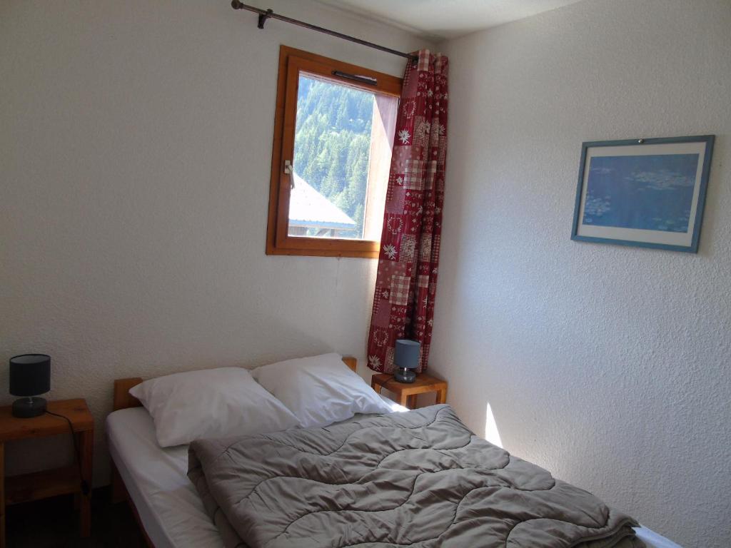 Schlafzimmer mit einem Bett und einem Fenster in der Unterkunft Appartement Valfréjus, 2 pièces, 6 personnes - FR-1-561-18 in Valfréjus