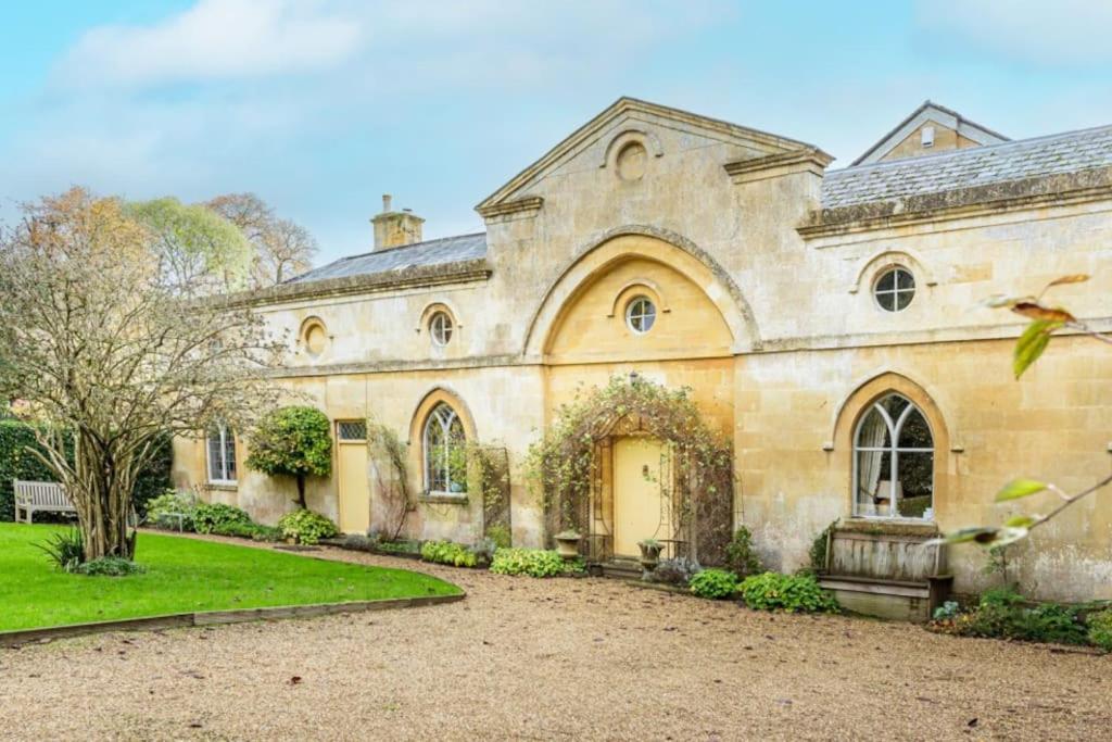 a large stone house with a yard at Artisan Hall: 4BD Stunning Grandeur in Cotswolds in Toddington