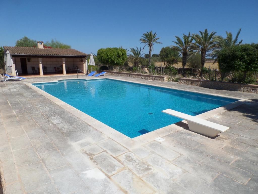 a swimming pool in front of a house at Sa Bassa Crua Agroturismo in Sa Torre