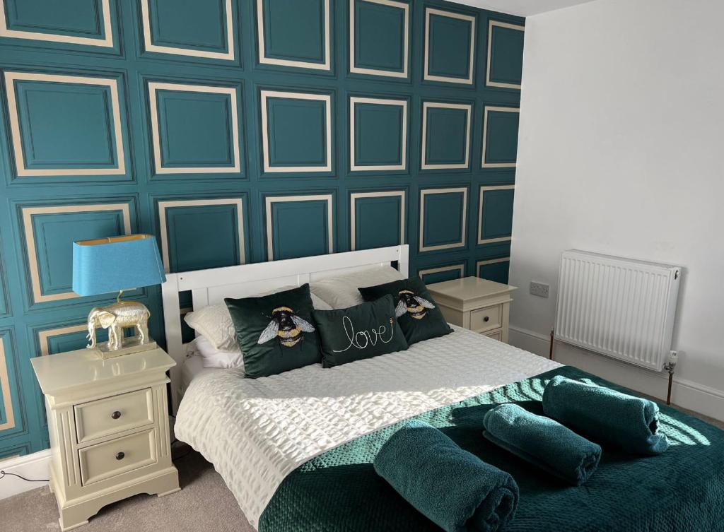 a bedroom with a bed with a blue accent wall at Alsager Town Centre Apartment in Alsager