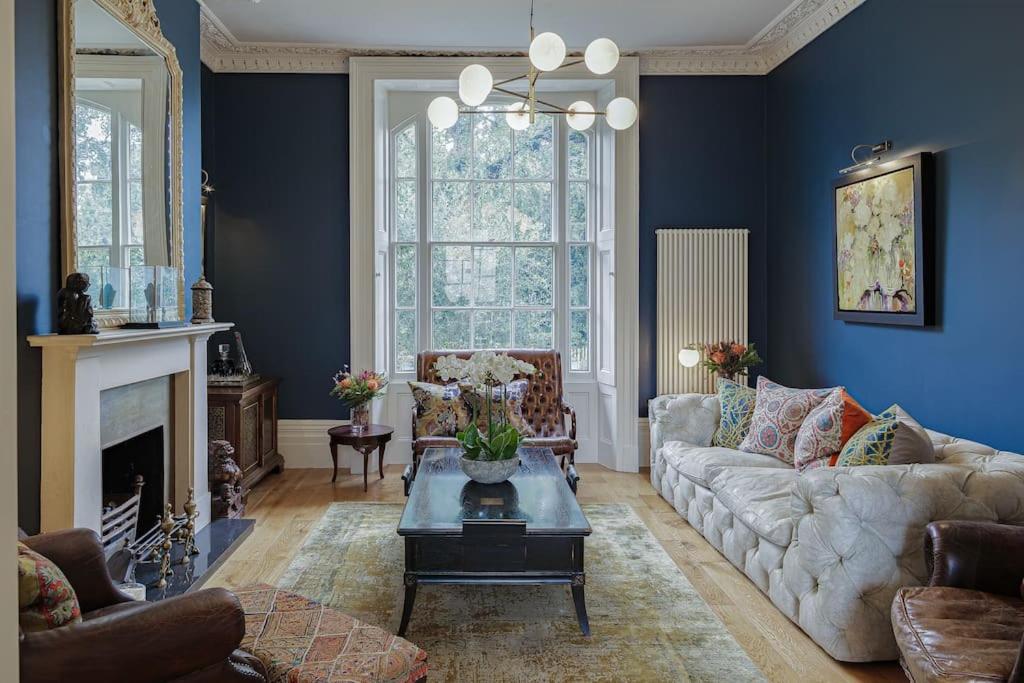 a living room with a couch and a table at Clarence House: 4BD Georgian Townhouse in Cheltenham