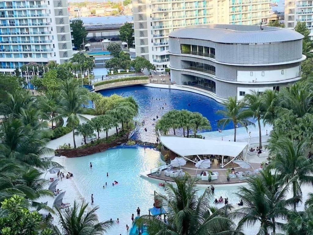 a large pool in a resort with people in it at Azure Staycation Near the Airport in Manila