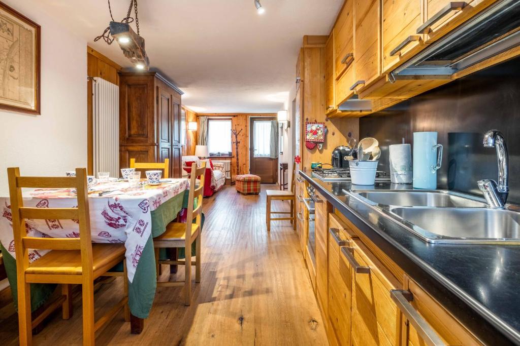 a kitchen with a table and a sink and a counter at LUVI - Courmayeur in Courmayeur