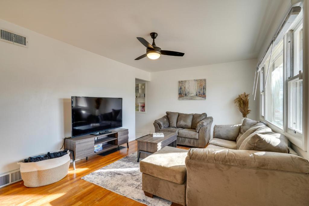 a living room with a couch and a flat screen tv at Chic Pueblo Vacation Rental Home Near Fairgrounds! in Pueblo