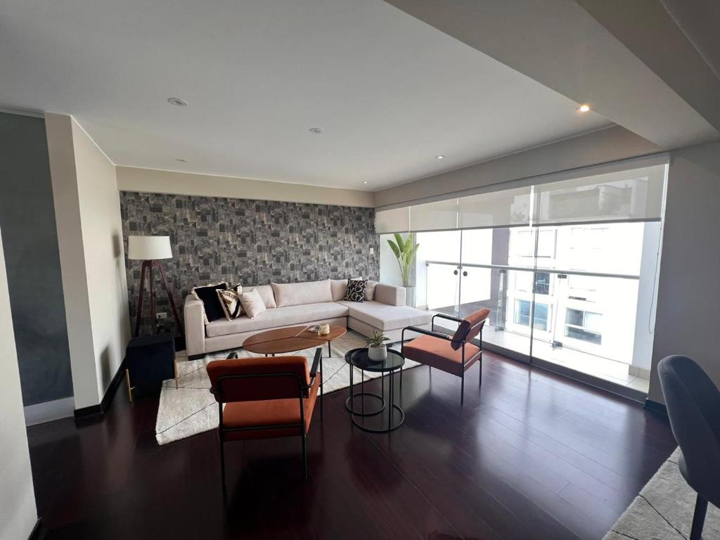 sala de estar con sofá, mesa y sillas en El Golf los inkas luxury Penthouse, en Lima