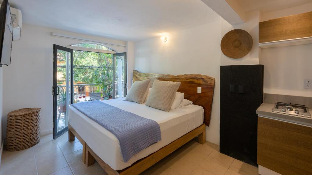 a bedroom with a bed and a kitchen with a window at Casa Lucas in Puerto Vallarta