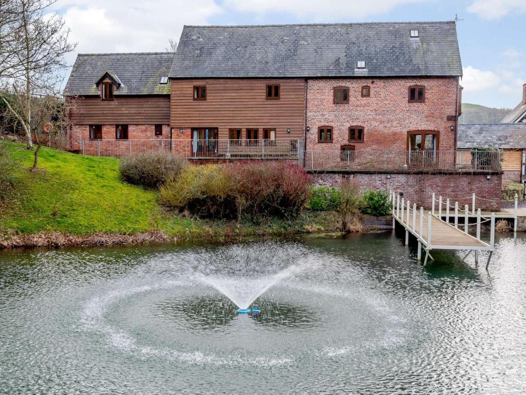 a fountain in the water in front of a building at 3 Bed in Bettws Cedewain 86785 in Bettws Cedewain