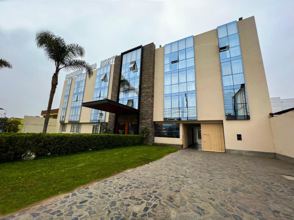 a building with a palm tree in front of it at Hotel Hacienda Lima Norte in Lima