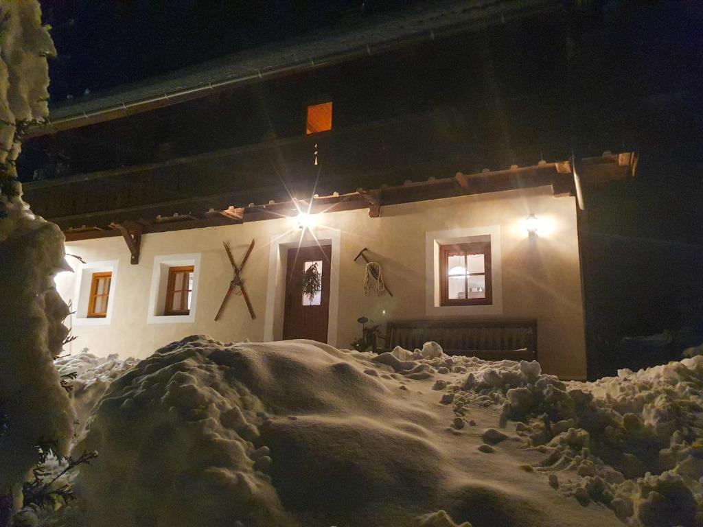 een huis is 's nachts bedekt met sneeuw bij Haus Lahner in Bad Bleiberg