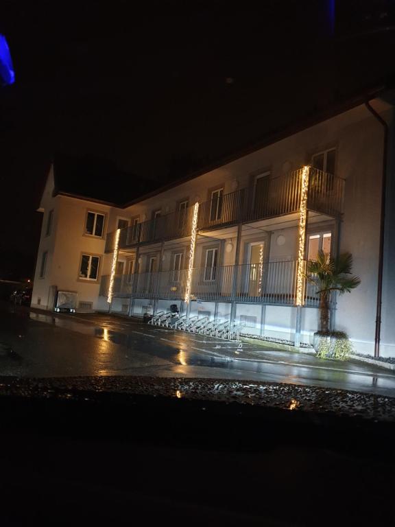 a building with lights on the side of it at night at Business Apartment Turgi in Turgi