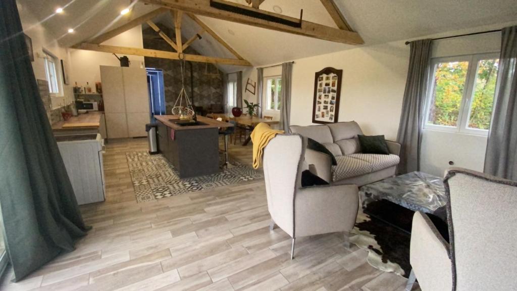 a living room with a couch and a kitchen at Maison de charme 3 chambres in Saligny-sur-Roudon