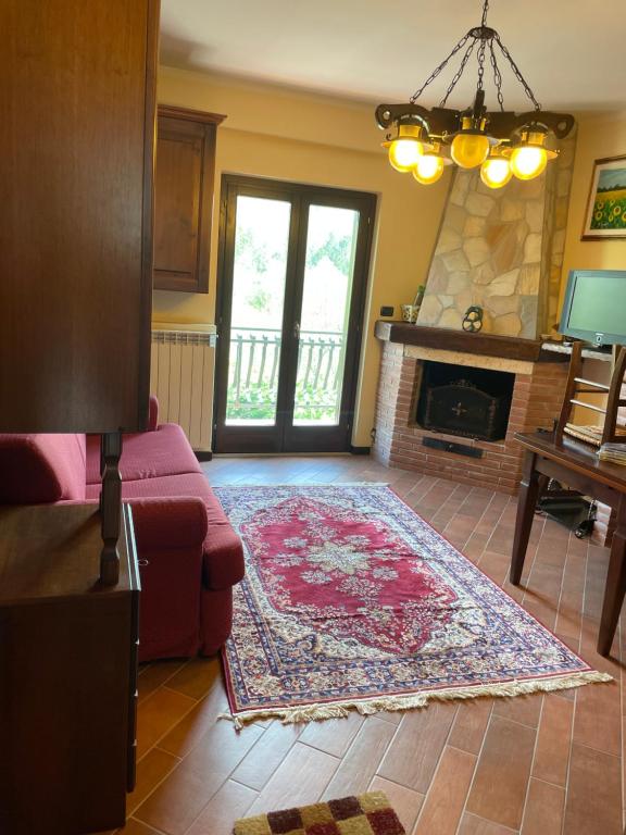 Vittoria Sweet Home في Ateleta: غرفة معيشة مع أريكة ومدفأة
