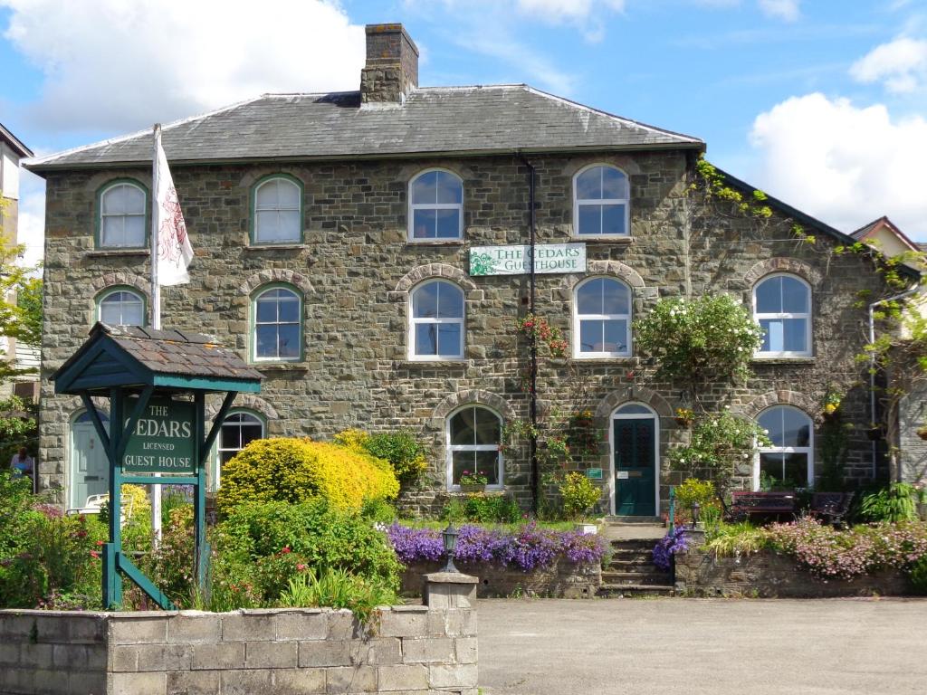 a stone house with a sign in front of it at The Cedars in Builth Wells