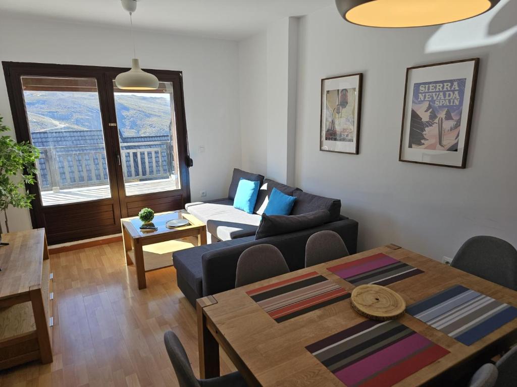 IMEDA Apartamento LOS ALPES I في سييرا نيفادا: غرفة معيشة مع طاولة وأريكة