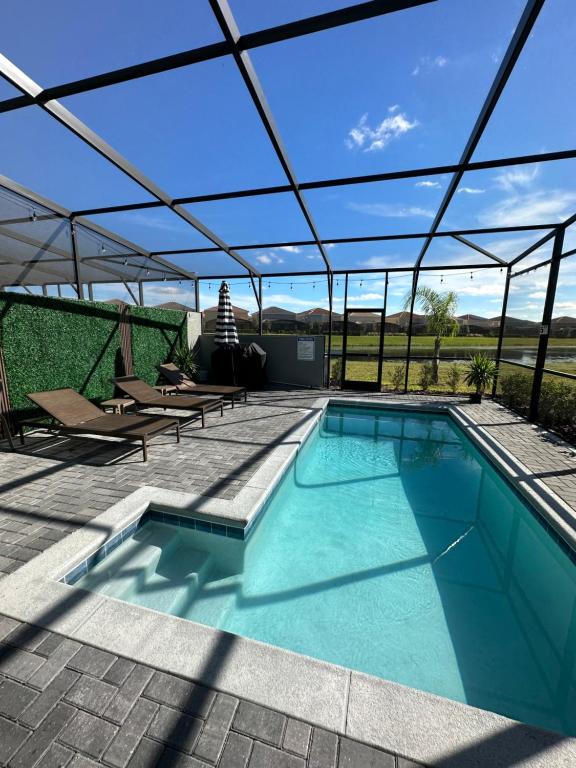 a swimming pool with a roof over a patio at Orlando Relax in Davenport